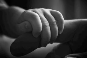 The child holds the father's finger