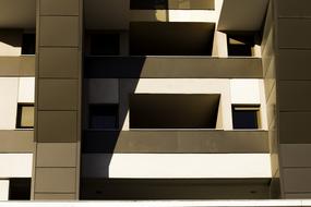 Beautiful, brown and white building with balconies, in light