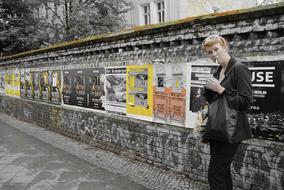 smoking girl near the posters on the fence
