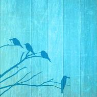 silhouettes of birds on a branch on a blue background