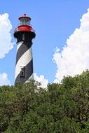 the lighthouse is black and white with a red roof