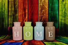colored vases with the inscription house on a background of colored wooden wall