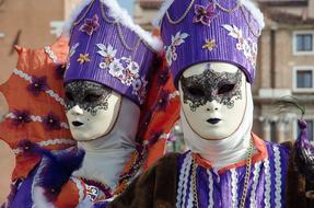 people in white masks and purple suits