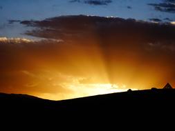 sun rays shining from behind the mountains