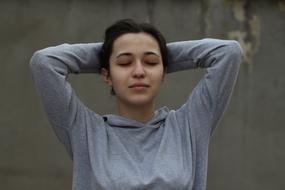 young Girl posing with hands on back of head and closed eyes