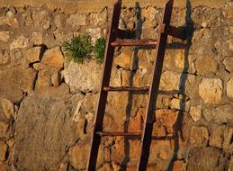 meth allic staircase against a stone wall