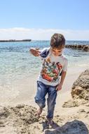 photo of Child Boy playing in sand on beach