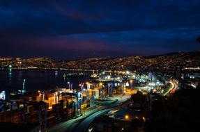 Beautiful and colorful cityscape of Valparaiso, with lights, at night, in Chile