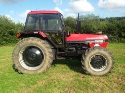 red farm tractor in a meadow