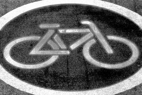 White and black "bike" sign on the road