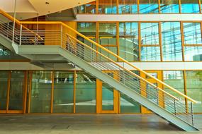 staircase with yellow railing at modern facade