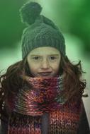 child girl in winter clothe at green background