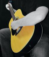 man playing yellow acoustic guitar