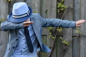 child Boy wearing blue tie suit dancing at wooden fence