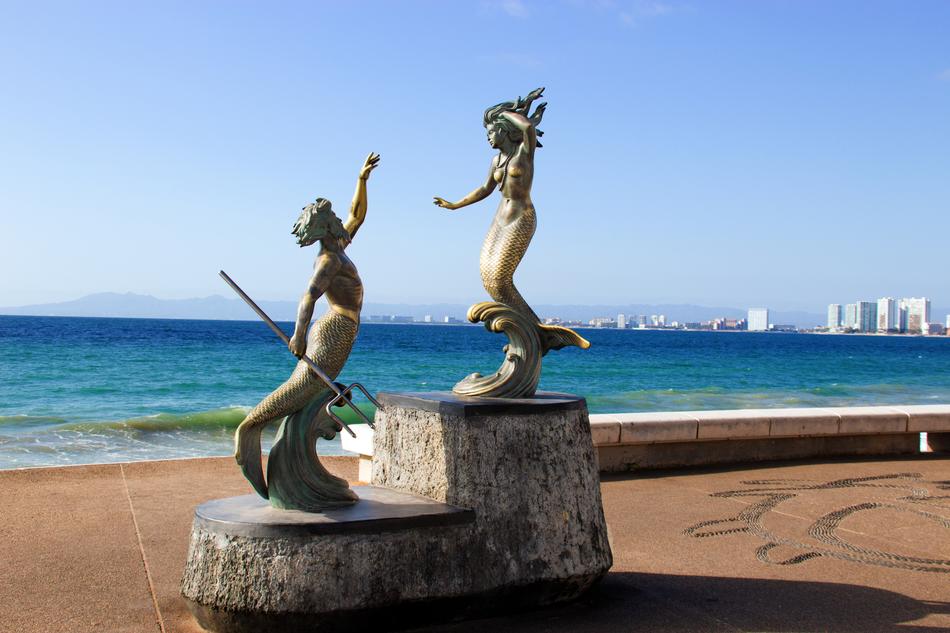 sculptures of mermaids by the sea