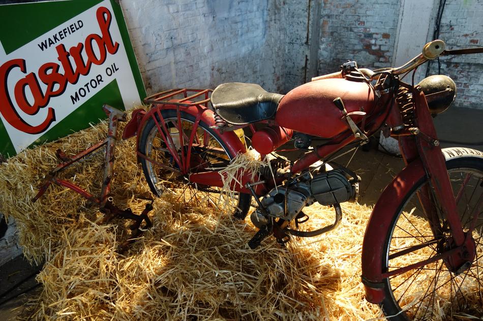 the motorcycle is red at the hay
