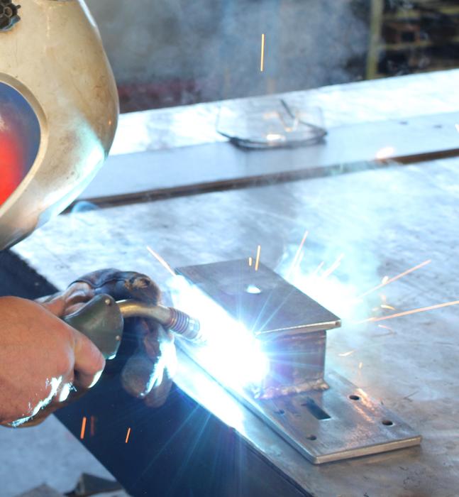 Person in protective mask, doing metal work with the detail