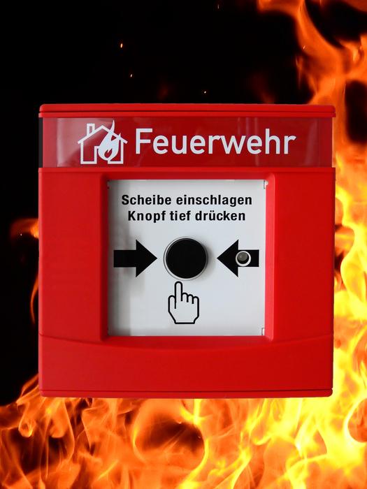 'Push button' for fire alarm, at black background with flame