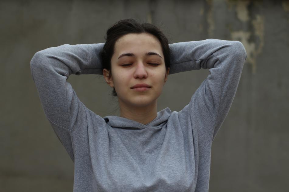 young Girl posing with hands on back of head and closed eyes