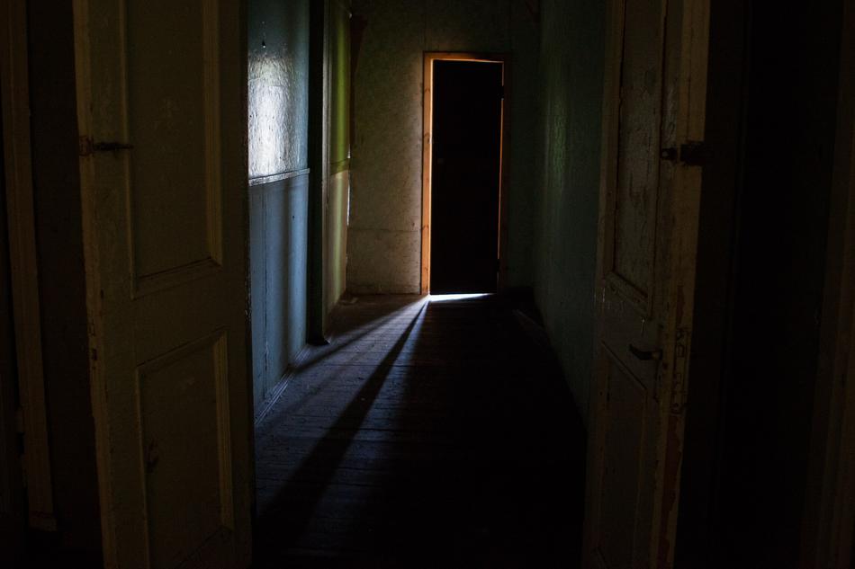 a dark corridor with a door