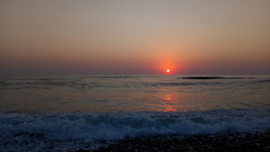 red sun by the sea