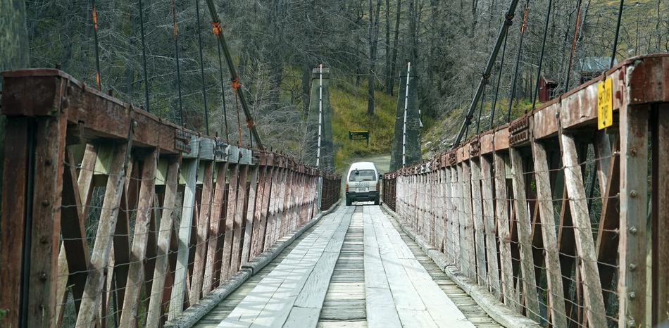 car driving over a stone bridge