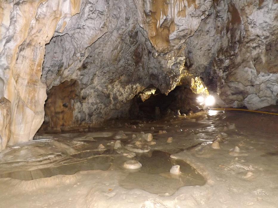 cave with rock outcrops and a river