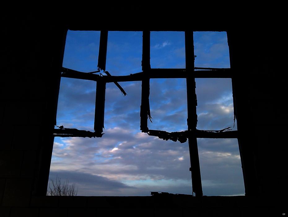 Photo of broken window at background of blue sky