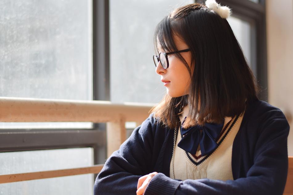 cute girl with glasses by the window