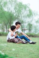 happy asian man hugging Child boy on lawn, Paternity