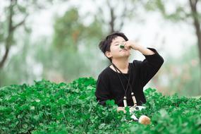 child in green bushes in the park