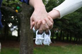 parents hold shoes for the newborn