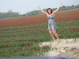 girl jumping in a field of tulips