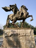 stone sculpture of a rider in the park