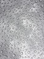 Close-up of the shiny, grey glass surface, with the water droplets