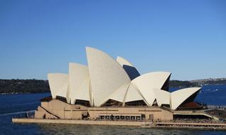 Beautiful Sydney Opera House, among the blue water, in Australia, at blue sky on background