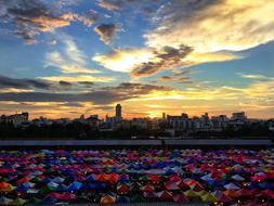 multi-colored umbrellas on the embankment along the canal