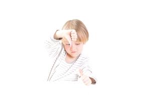 Blonde boy with thumb down at white background