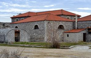 stone house with a brown roof in Greece
