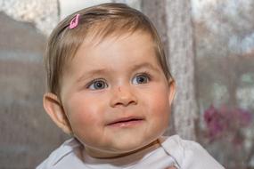 cute little girl with a pink hairpin on her head