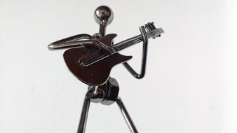 Shiny metal guitarist figure at white background