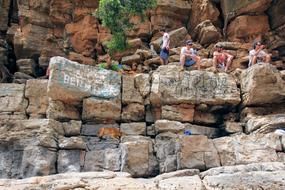 tourists with a dog on large rocks