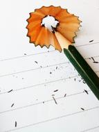Pencil with the colorful shavings, on the wooden surface