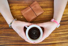 hands on the table with a mug of coffee