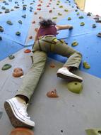 young girl climbing on painted wall