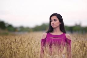 photo of a girl in a purple dress on a wheat field
