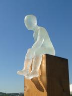 Glass sculpture of a man on stone