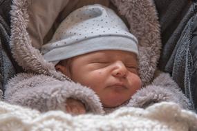 photo of a sleeping baby in warm overalls
