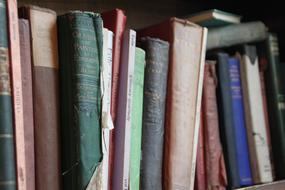 row of weathered books on shelve