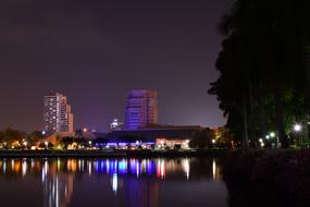 night illumination of city buildings is reflected in the water